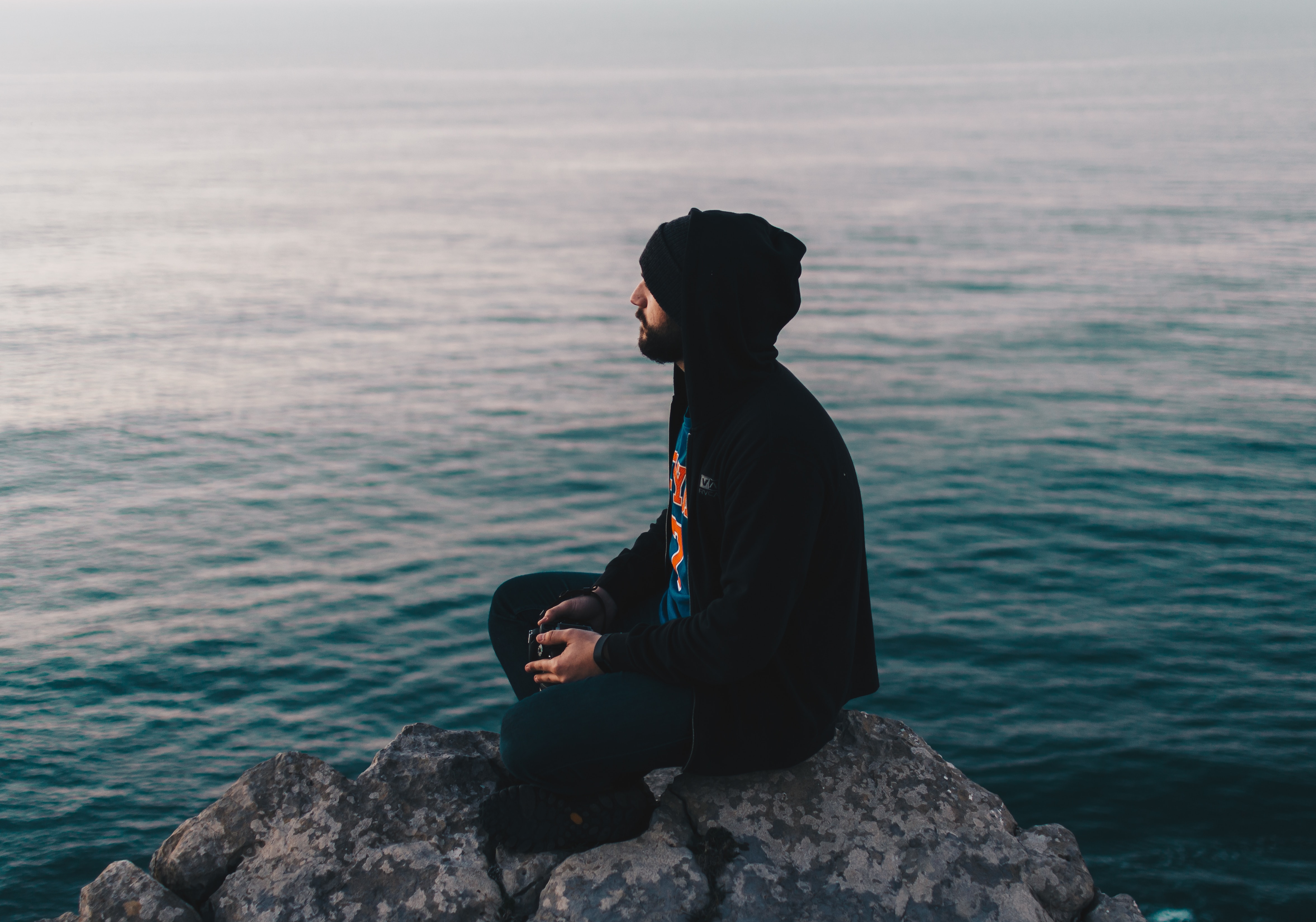 Man sitting on a rock over looking water